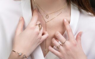 A woman trying to pick between different pieces of gold jewelry